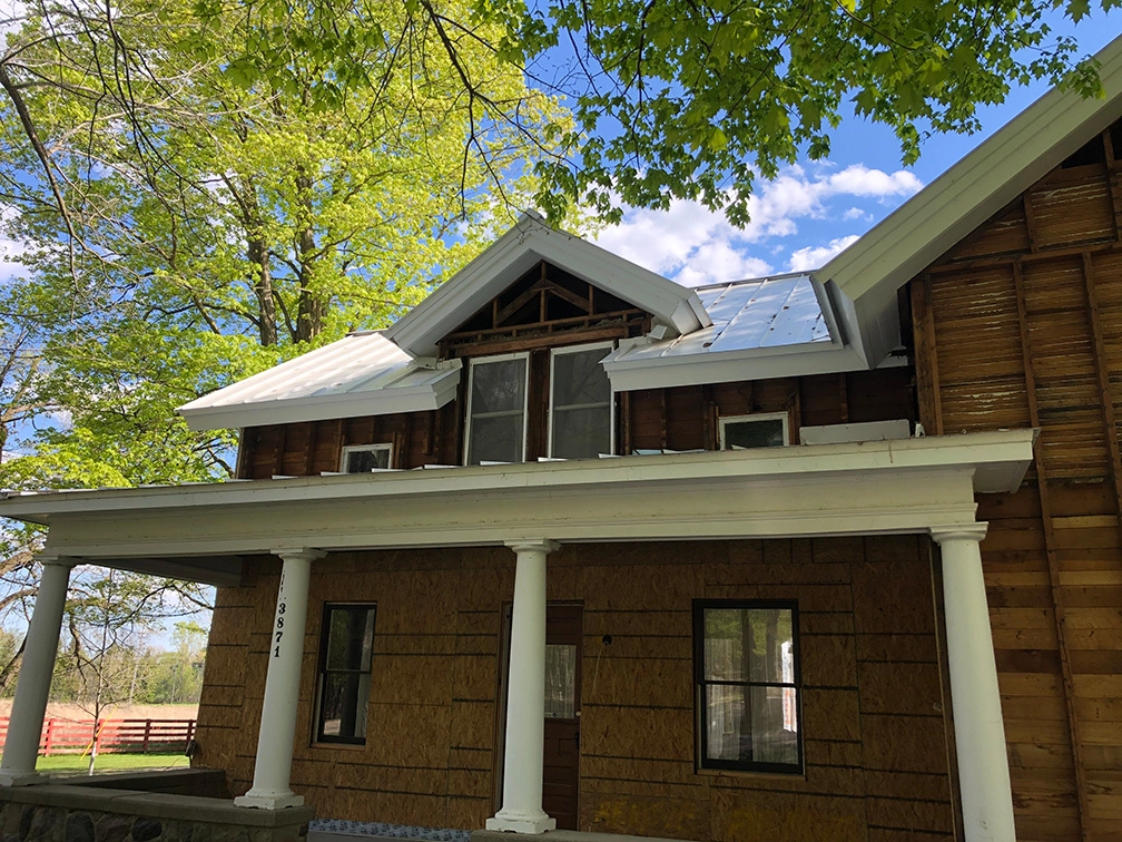 House with the siding tore off getting repaired for asbestos abatement.